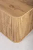 A close-up view of the corner of a wooden cabinet with a fluted design. Voir les images du produit