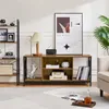 A living room scene featuring a TV stand with various decorative items and a large framed poster on the wall. Podgląd zdjęcia produktu