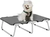 A small white dog wearing a green harness sits on a raised gray pet bed against a white background. Voir les images du produit