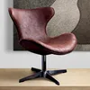 A brown leather chair with a black base is shown on a wooden surface against a textured background. Produktbild-Vorschau