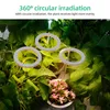Three circular grow lights are positioned above lush green plants, with a small pot of pink succulents in the foreground. Náhľad obrázku produktu