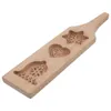 A wooden cookie mold with three different shapes carved into it: a star, a heart, and a bell. Náhľad obrázku produktu