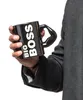 A person's hand holds a black mug with white text. Anteprima dell’immagine prodotto
