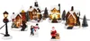 A collection of illuminated Christmas village houses and figures, covered in snow, set against a white background. Produktbild-Vorschau