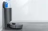 A robot vacuum cleaner docked in its charging and dust collection station, with a dust bag being inserted into the station. Náhľad obrázku produktu