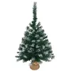 A small, artificial Christmas tree with flocked branches, standing in a burlap sack base. Anteprima dell’immagine prodotto