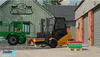 A forklift is loading colorful rolls onto a trailer next to a building. Náhled obrázku produktu
