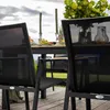 An outdoor dining set with chairs and a table, set on a wooden deck. Produktbild-Vorschau