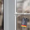A close-up view of a white tension rod mounted on a window frame, with a tag attached. Voir les images du produit