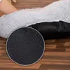 A close-up view of the bottom of a dog bed, showing its anti-slip nubs and the fluffy material of the bed. Náhľad obrázku produktu