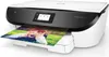 A white and black HP Envy photo printer is shown printing a picture of a child. Voir les images du produit