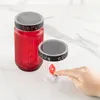 Two solar-powered LED grab lights (one red, one clear) are displayed on a white marble surface. A hand is shown pressing the flame of the clear grab light. Produktbild-Vorschau
