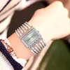 A woman's wrist wearing a silver watch and bracelet. Produktbild-Vorschau