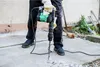 A person is using a demolition hammer to break concrete. Anteprima dell’immagine prodotto