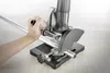 A hand is holding a metal pipe on a cutting stand with an angle grinder. Produktbild-Vorschau