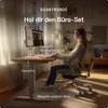 A woman is working at a height-adjustable desk in a home office setting. Produktbild-Vorschau