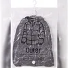 A gray jacket inside a clear vacuum storage bag, hanging on a hook. Anteprima dell’immagine prodotto