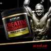 A tub of Activlab Creatine Monohydrate is shown next to a muscular bodybuilder. Náhled obrázku produktu
