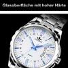 A close-up shot of a men's wristwatch with a silver band and a white face, set against a black background. Produktbild-Vorschau