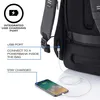 A close-up view of the back of a backpack, highlighting its integrated USB charging port and a connected smartphone. Produktbild-Vorschau