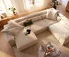 A spacious living room with a large sectional sofa, coffee table, and plants. Produktbild-Vorschau