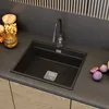 A black kitchen sink with a chrome faucet is shown on a dark countertop, with wooden cabinets below. Anteprima dell’immagine prodotto
