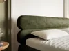 Close-up of a green upholstered bed headboard with a white pillow. Produktbild-Vorschau