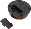 The underside of a round, orange and black electronic device, showing a battery compartment and speaker grille. A detached battery cover is in the foreground. Náhľad obrázku produktu