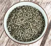 A bowl of dried monkshood berries on a wooden surface. Produktbild-Vorschau