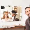 Vier quadratische Spiegelplatten, die eine Frau reflektieren, die sich von einem Friseur die Haare stylen lässt, mit einem lächelnden Mann im Vordergrund Anteprima dell’immagine prodotto