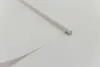 A close-up view of a white fabric material, possibly a curtain or blind, with a rolled edge and a rod inserted. Produktbild-Vorschau
