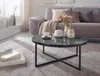 A living room scene with a couch, coffee table, and rug. Produktbild-Vorschau