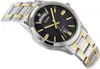A close-up shot of a men's wristwatch with a black dial, silver and gold band, and gold accents. Podgląd zdjęcia produktu