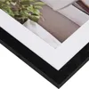 A close-up view of a black picture frame with a white matting, showing a portion of the image within. Produktbild-Vorschau