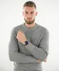 A man wearing a grey sweater and a silver watch with a blue face. Náhľad obrázku produktu