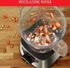 A close-up shot of a blender with almonds being dropped into it, set against a wooden background. Voir les images du produit