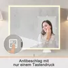 A woman is shown touching her face in a lighted mirror, with a close-up inset of a touch icon and text indicating anti-fog functionality. Náhled obrázku produktu