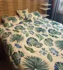 A bed with tropical leaf patterned bedding and a pillow with an anchor design. Anteprima dell’immagine prodotto