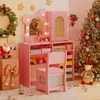 A pink children's vanity set with a chair, decorated for Christmas with a wreath, Santa Claus figure, and a Christmas tree. Voir les images du produit