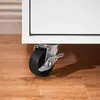 Close-up of a caster wheel on a white piece of furniture, resting on a wooden floor. Produktbild-Vorschau