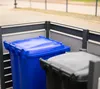 Two trash bins are shown in a covered outdoor enclosure. Náhled obrázku produktu