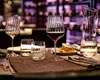 A table setting with wine glasses, a carafe, and food, suggesting a dining or restaurant environment. Náhled obrázku produktu