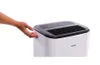 A hand is shown interacting with the side of a white dehumidifier with a black top. Anteprima dell’immagine prodotto