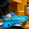 A person wearing a blue safety shoe with yellow text, standing next to yellow industrial machinery. Produktbild-Vorschau