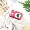A red Kodak camera is placed on a white textured fabric, with a woven beige item and a green leaf in the background. Podgląd zdjęcia produktu