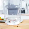 A close-up shot of a water filter pitcher with water being filtered. Produktbild-Vorschau