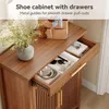 A close-up view of a wooden shoe cabinet with an open drawer, showcasing its interior and contents. Náhľad obrázku produktu