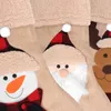 A close-up view of three Christmas stockings with embroidered characters. Produktbild-Vorschau