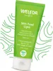 A green tube of Weleda Skin Food Light cream is shown against a white background with green abstract wavy lines. Voir les images du produit