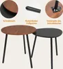 Two nesting coffee tables, one with a brown wood-grain top and the other with a black top, are shown against a light gray background. Close-up insets highlight the table edge, a leg tip, and the underside attachment of a leg. Produktbild-Vorschau